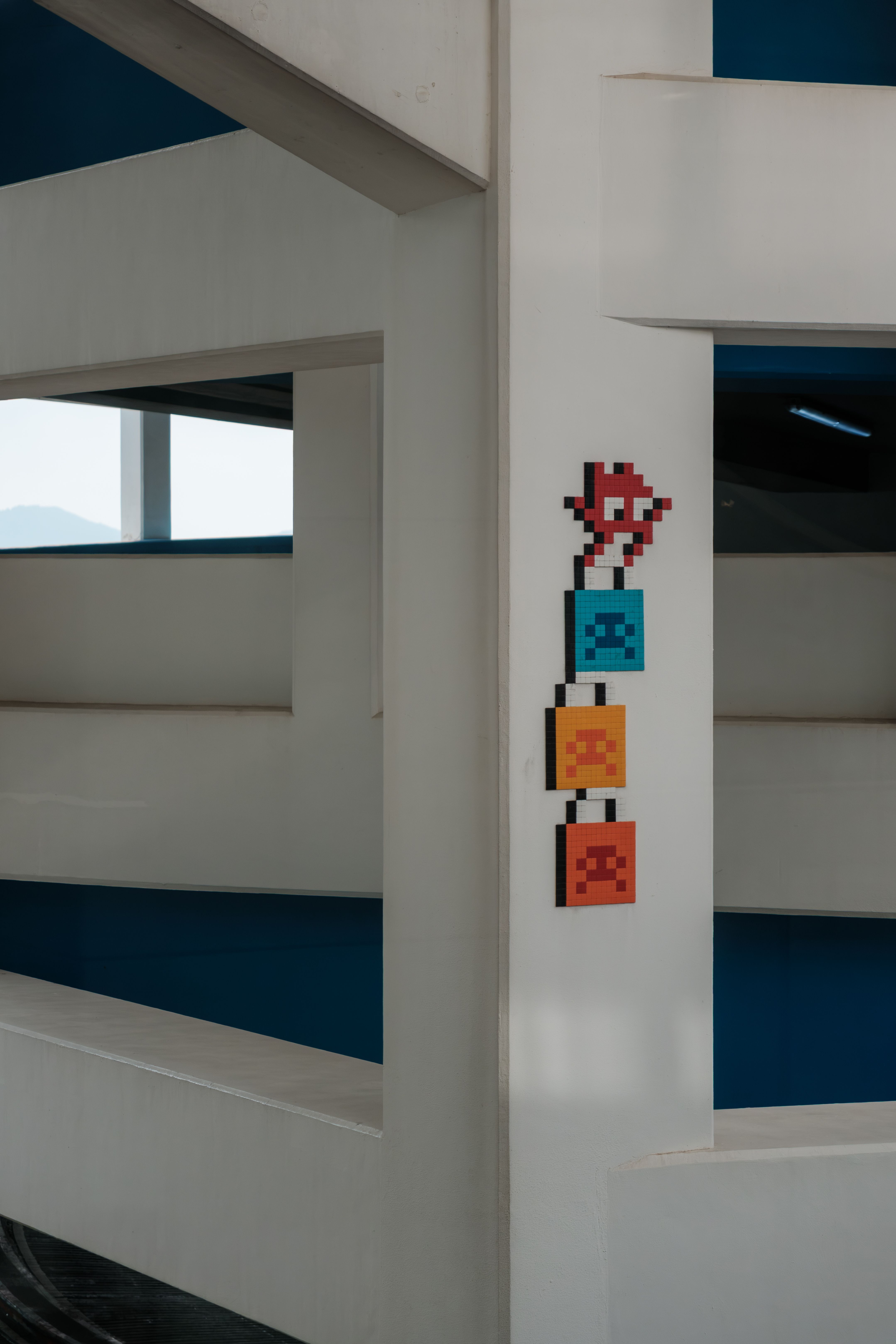 Colorful pixel art on a modern white structure in Hong Kong.
