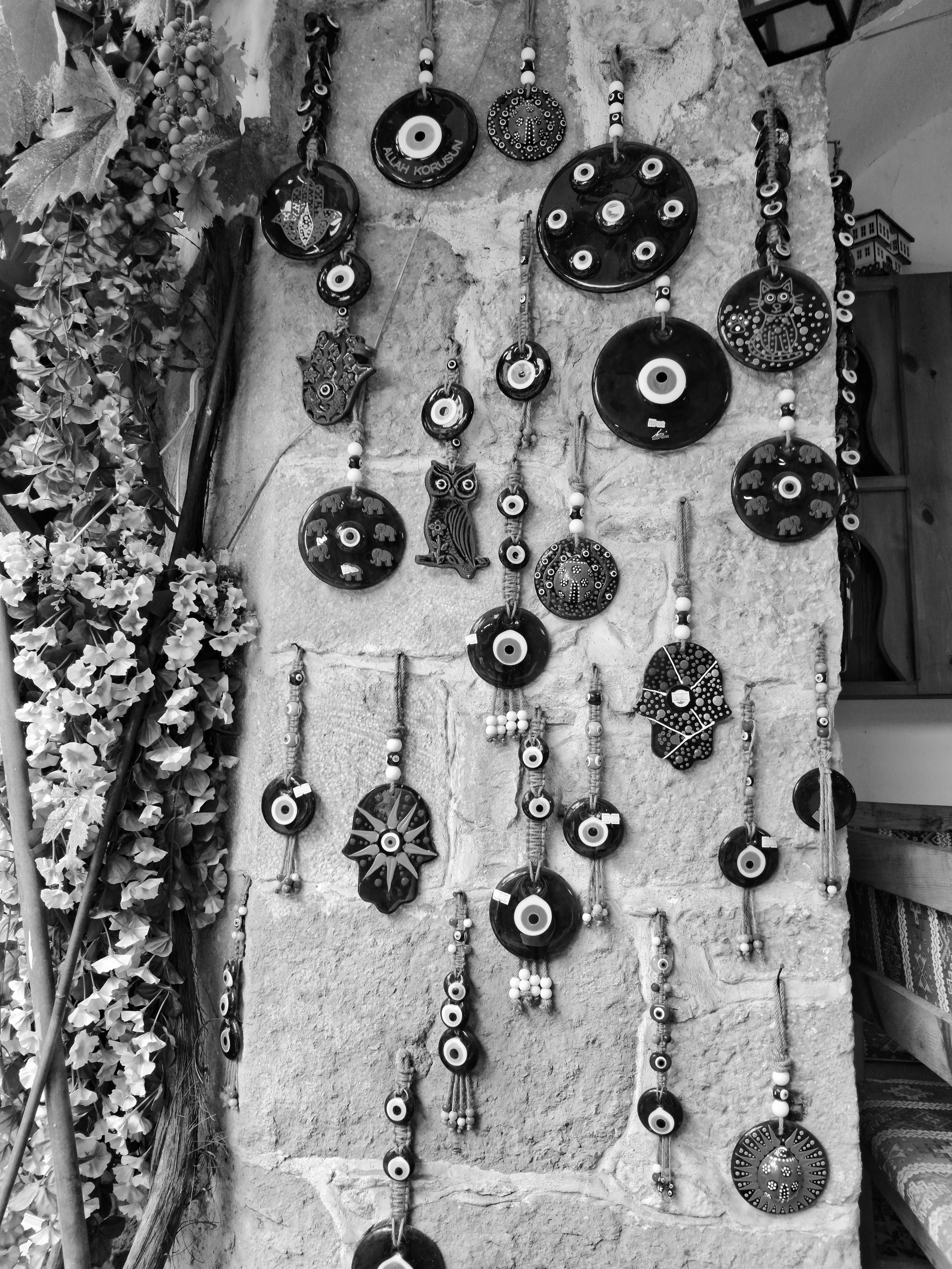 Black and white photo of traditional Turkish Nazar amulets displayed on a stone wall in Kastamonu.