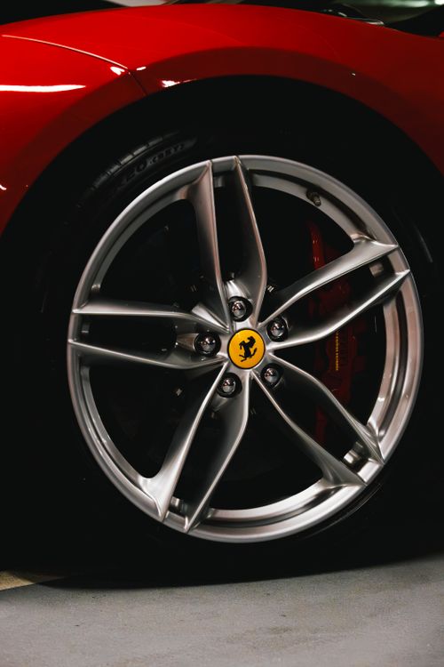 Free Close-up of a Ferrari wheel with a silver rim and yellow center cap. Captured in Dublin. Stock Photo