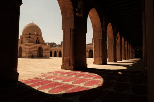 Free View of Ibn Tulun Mosque's courtyard with arches and carpet under sunlight in Cairo, Egypt. Stock Photo