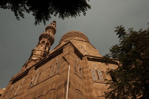 Free A dramatic angle showcases the detailed architecture of Sultan Hasan Mosque under a muted sky in Cairo, Egypt. Stock Photo
