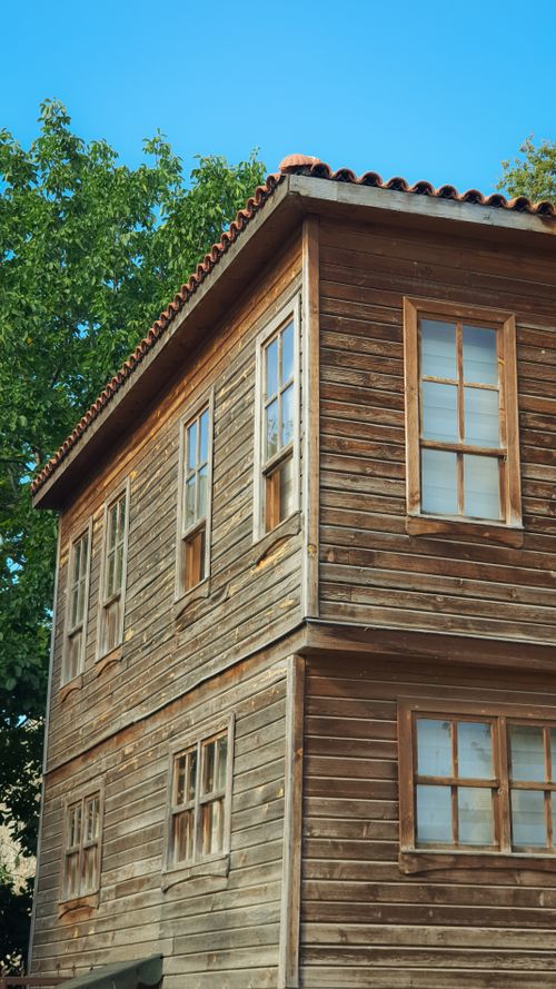 Free Charming rustic wooden house exterior with traditional architecture under a clear blue sky. Stock Photo