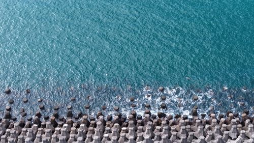 Free A stunning aerial view of a hexagonal breakwater with vibrant blue ocean waves crashing against it. Stock Photo
