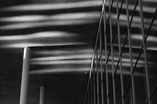 Free Architectural shadows create abstract patterns on a building facade in black and white. Stock Photo
