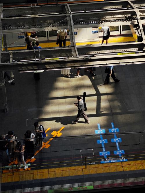 Free A busy subway platform with commuters and directional markings under stark lighting. Stock Photo