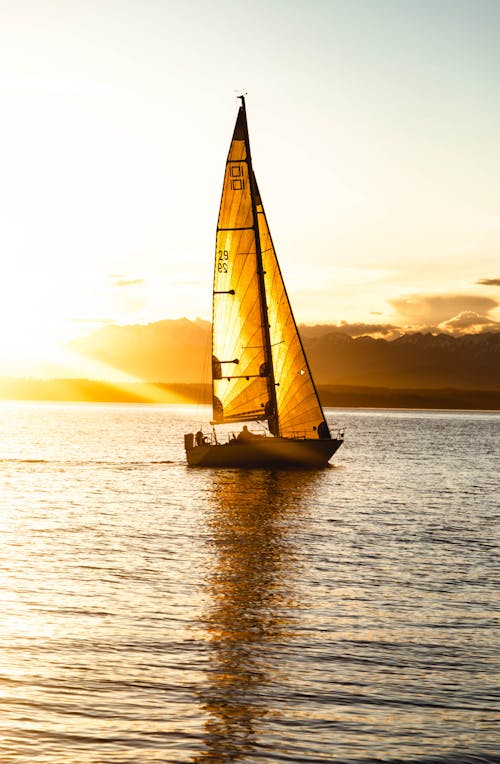 Silhouette Of Sailboat On Sea During Sunset