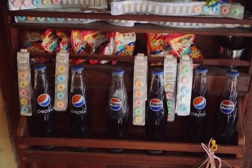 Free Vintage display of Pepsi bottles with nostalgic candy in a wooden rack. Stock Photo