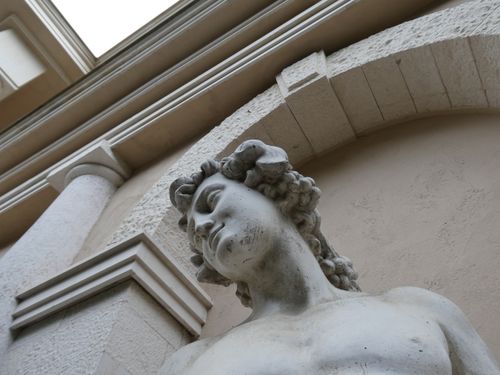 Free A close-up view of a marble statue against classical architectural elements. Stock Photo