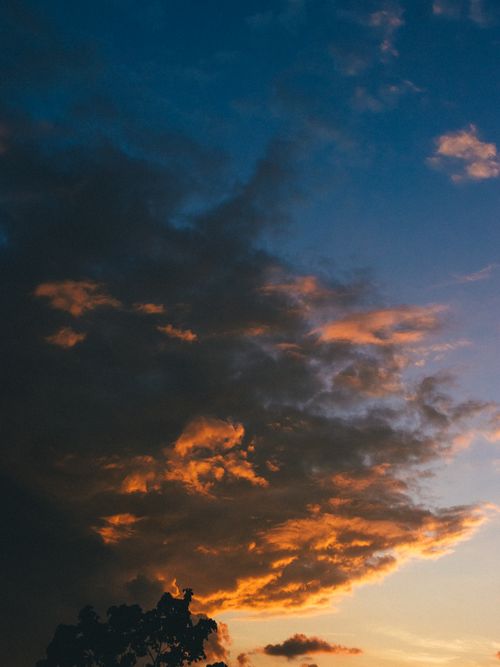 Free A vibrant sunset sky with dramatic clouds, creating an artistic and moody atmosphere. Stock Photo