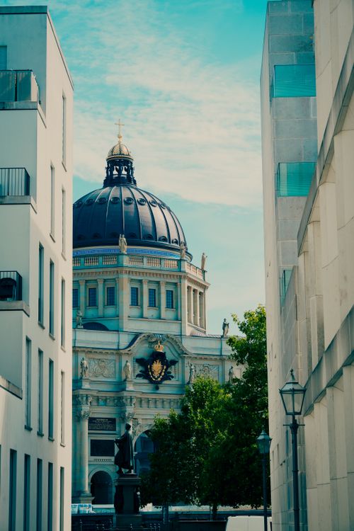 Free View of Berlin Cathedral framed by modern buildings, showcasing classic and contemporary architecture. Stock Photo