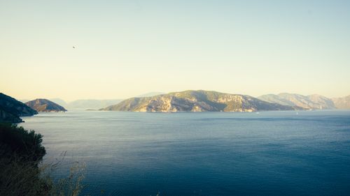 Free Peaceful seaside view of Marmaris coastline during sunset, showcasing serene blue waters and distant hills. Stock Photo