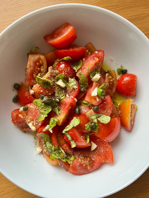 Free Vibrant salad with heirloom tomatoes, fresh basil, and capers. Perfect for a summer dish. Stock Photo