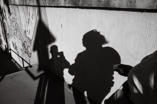 Free Shadows of people casting on an urban wall, creating a dramatic and artistic scene. Stock Photo