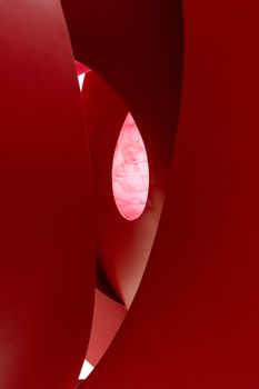 Intricate abstract shapes in vibrant red with minimalist lighting create a captivating visual.