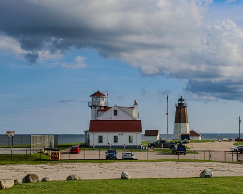 Free Scenic view of a historic lighthouse by the sea under dramatic clouds, perfect for travel and architecture themes. Stock Photo