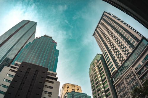 Free Looking up at modern skyscrapers in Pasig, Metro Manila, under a clear blue sky. Stock Photo