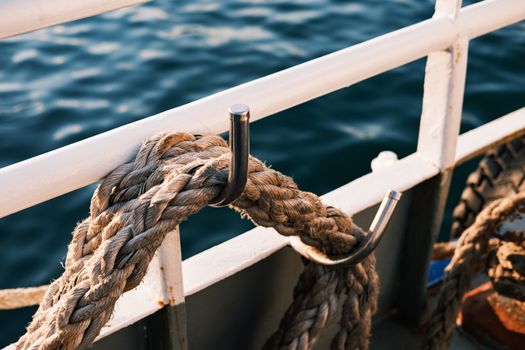 Close-up of a rope and hook on a boat railing in Istanbul, Türkiye, with water in the background.