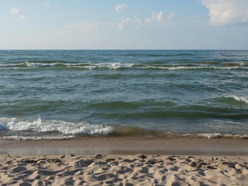 Free Calm waves and sandy shore at Lake Michigan's beachfront in Portage, Indiana during a sunny day. Stock Photo