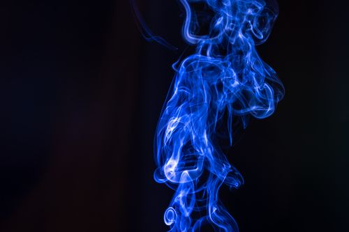 Free Abstract artistic image of swirling blue smoke against a dark backdrop, creating a mysterious, ethereal look. Stock Photo