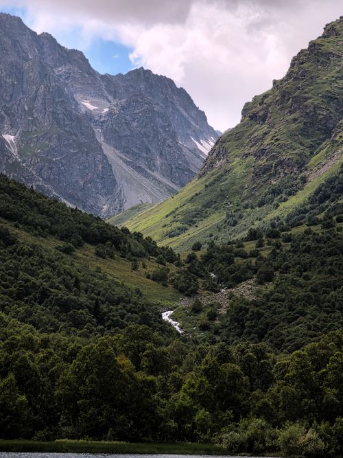 Free Spectacular view of green valleys and towering mountains under cloudy sky. Stock Photo