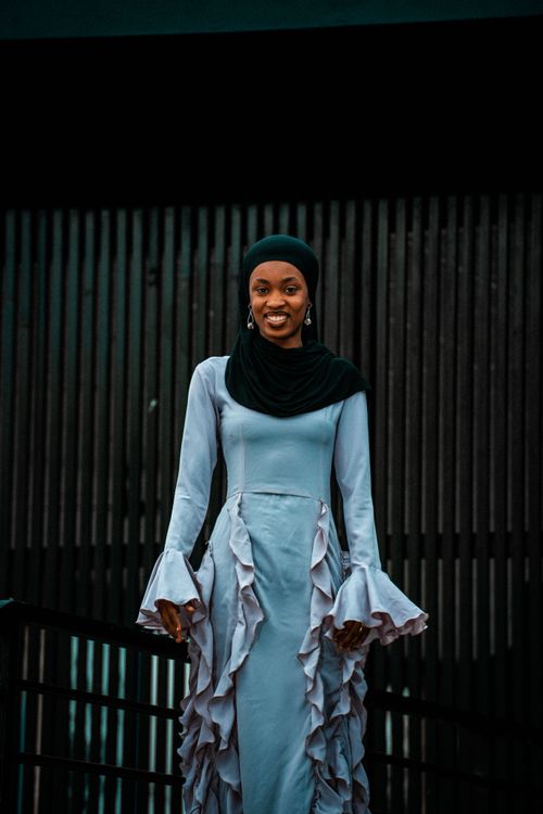 Free Stylish portrait of a woman in a ruffled dress and headscarf, exuding confidence and grace. Stock Photo