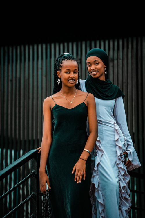 Free Charming portrait of two smiling young women in elegant dresses captured in Kigali, Rwanda. Stock Photo
