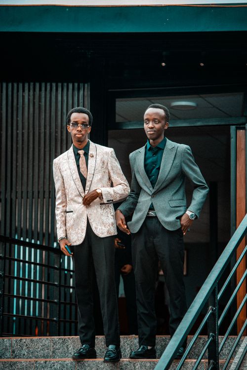 Free Two young men wearing stylish suits pose on stairs, exuding confidence and style. Stock Photo