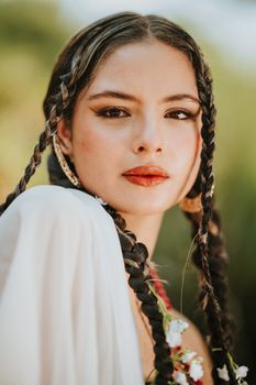 Close-up portrait of a woman with braided hair under natural sunlight.