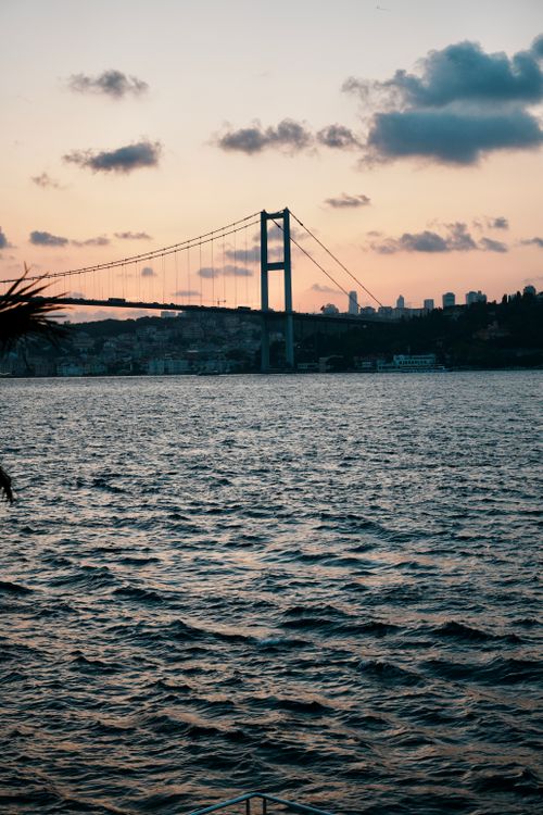 Free Scenic sunset view of the Bosphorus Bridge and Istanbul skyline from the water. Stock Photo