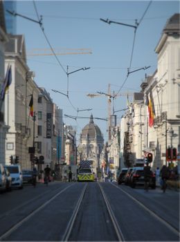Elegant street view in Brussels featuring the iconic Palais de Justice and tram tracks.