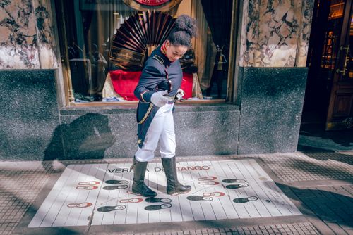 Free A street performer dressed in historical attire dancing over tango steps on a sidewalk in Buenos Aires. Stock Photo
