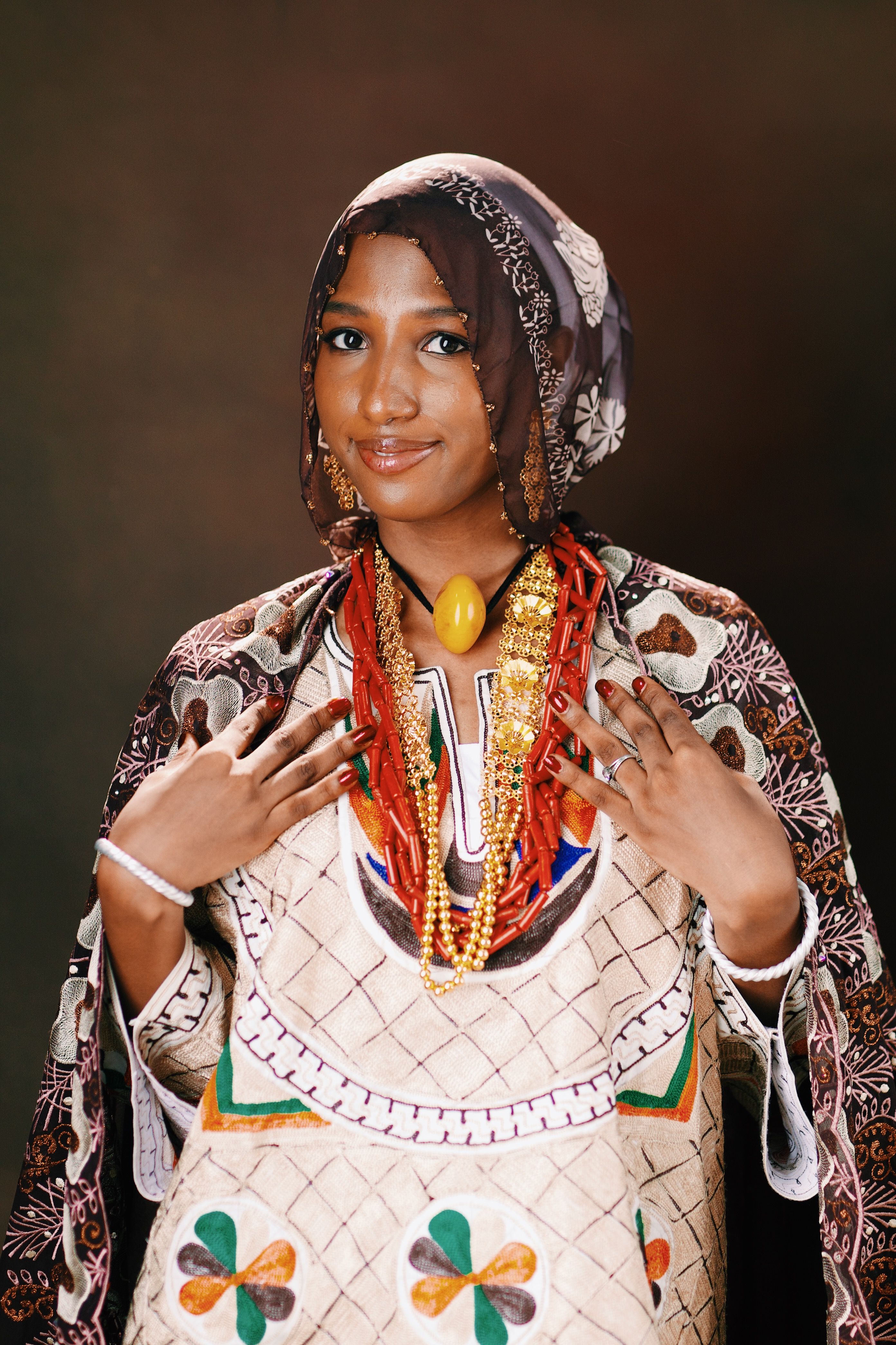Vibrant portrait of a woman wearing colorful traditional clothing and jewelry, showcasing cultural beauty.