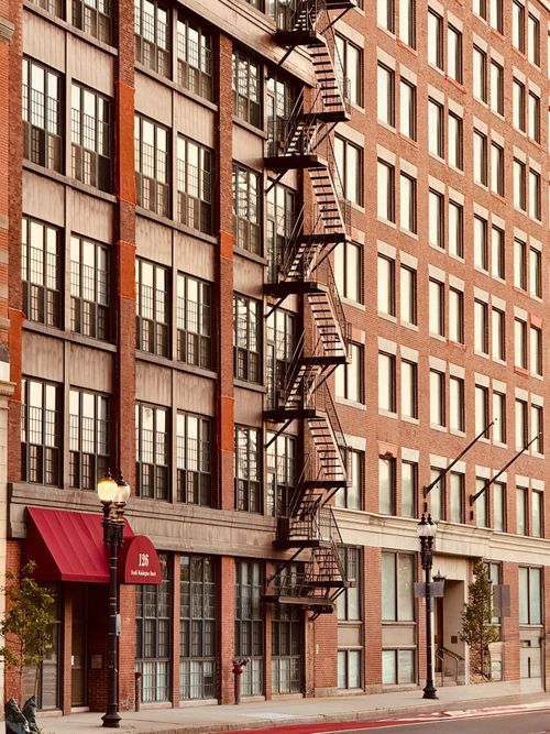 Free Charming historic brick building with fire escape in Boston, captured in warm afternoon light. Stock Photo