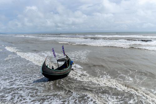 Free Traditional wooden boat in the waves at Cox's Bazar beach, Bangladesh. Stock Photo