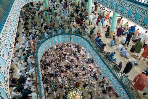 Free Aerial view of a large congregation gathered inside a mosque, showcasing vibrant patterns and community. Stock Photo