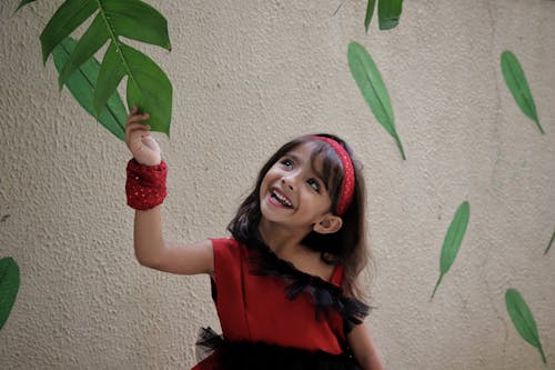 Girl In Red Dress Holding A Leaf