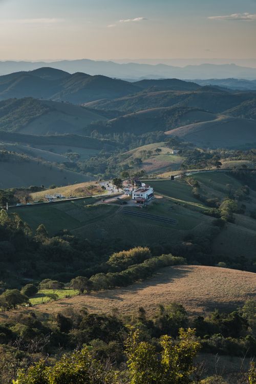 Free Captivating view of a solitary house amidst lush rolling hills under a clear sky. Stock Photo