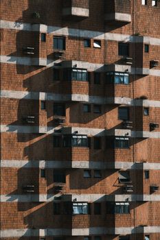 Geometric patterns of shadows on a brick apartment building facade.