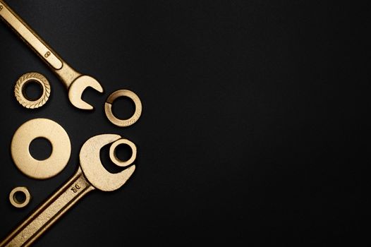 Stylish arrangement of gold-colored tools on a black background with ample copy space.