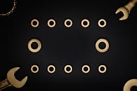 这幅静物作品以金色工具和洗衣机为特色，置于暗色背景之上，非常适合艺术与工业主题