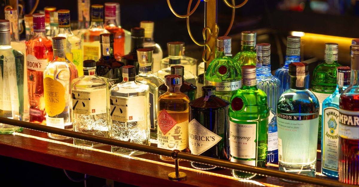 A colorful array of liquor bottles illuminated on a bar shelf, capturing a lively nightlife ambiance.