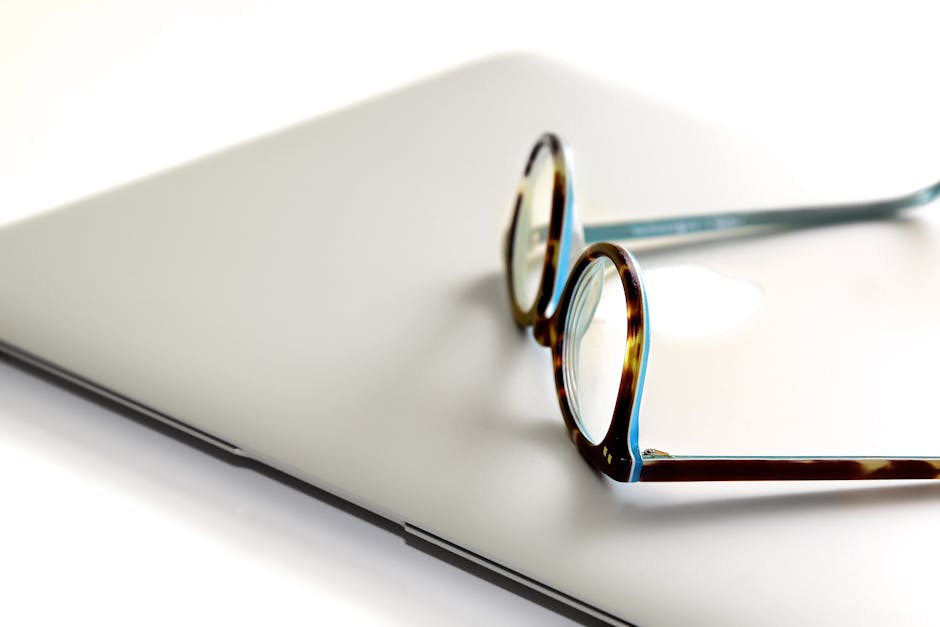Close-up of eyeglasses on a sleek, modern laptop, ideal for office or remote work settings.
