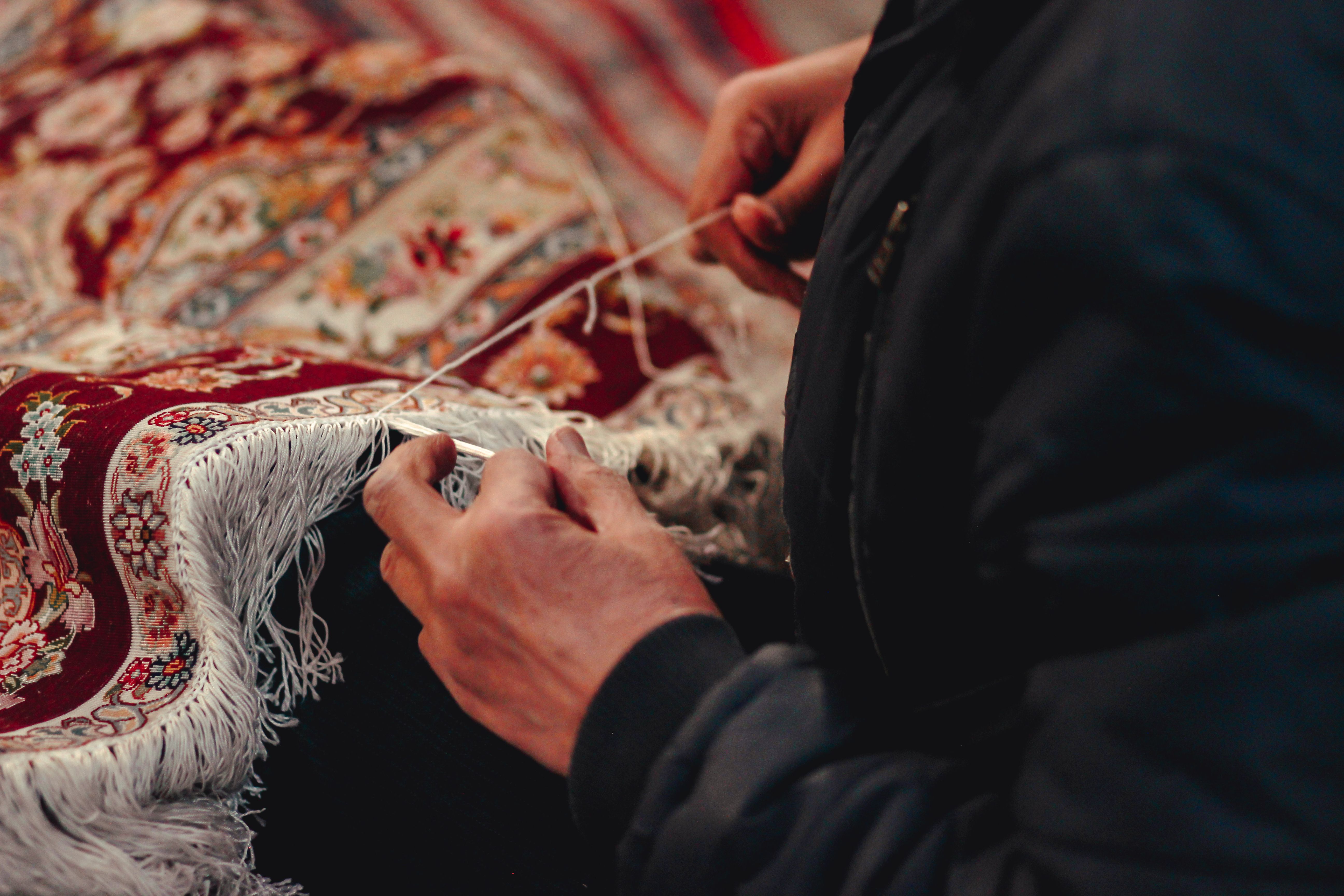 Artisan weaving an intricate hand-knotted Persian carpet in Tabriz