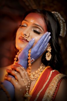 Elegant portrait of a woman in traditional Indian attire with vibrant colors and intricate details.