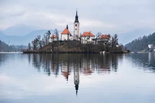 Free A serene view of Bled Island with church reflecting on Lake Bled in Slovenia. Stock Photo