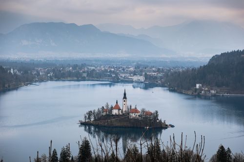 Free A stunning aerial view of Lake Bled with the iconic island church in winter, surrounded by mountains. Stock Photo