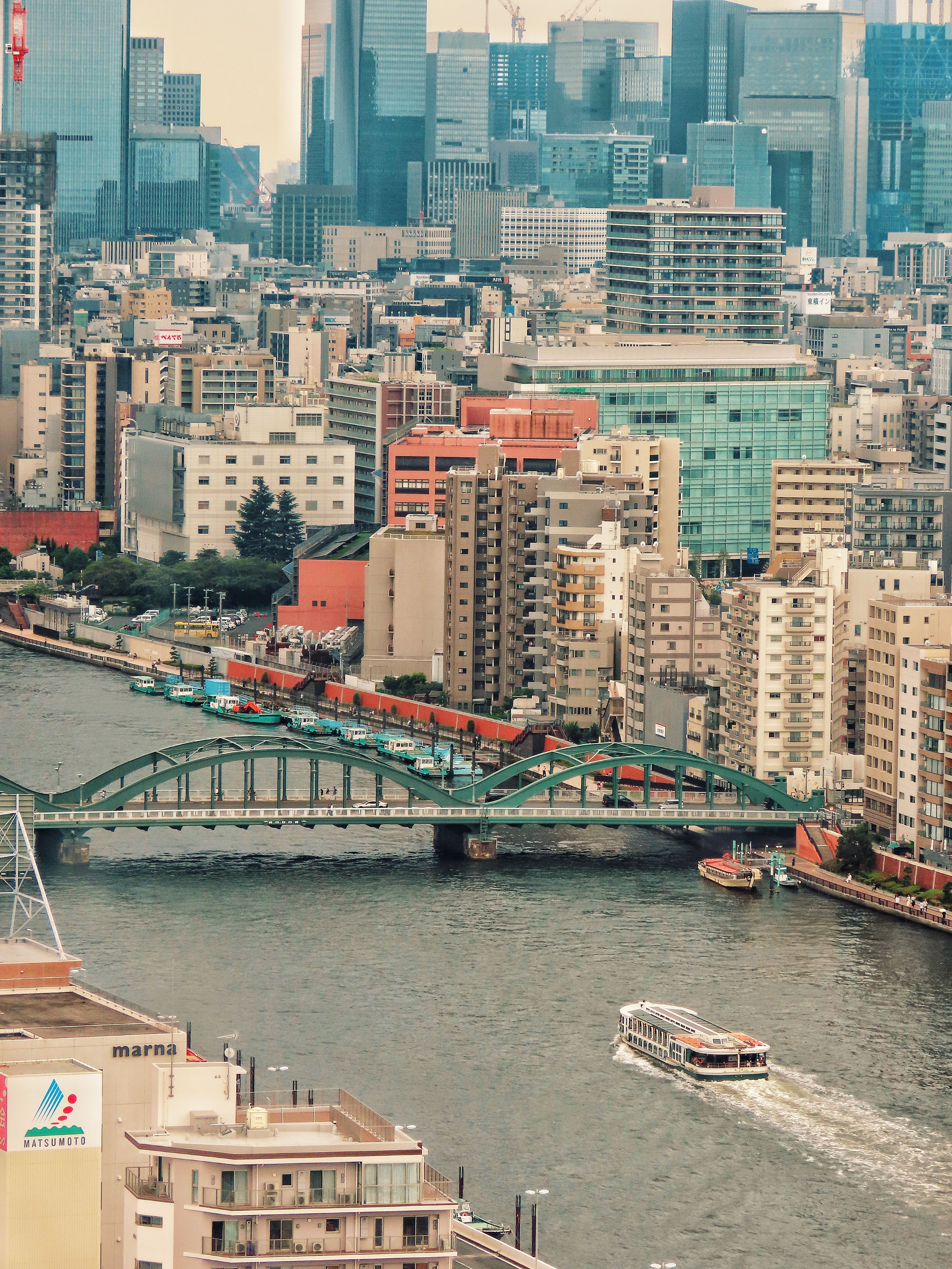 Explore the dynamic skyline of Tokyo featuring a historic bridge over the river.