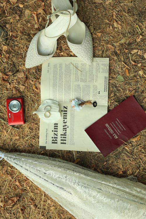 Free A charming flat lay of a wedding scene with shoes, a camera, and wedding rings on a natural background. Stock Photo
