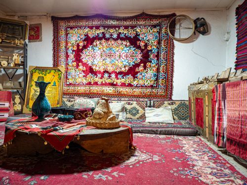 Free Inviting traditional room featuring vibrant rugs, cushions, and handcrafted decor. Stock Photo