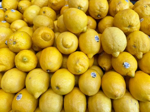 Free Bright yellow lemons stacked in abundance at a market in Maribyrnong, Australia. Stock Photo